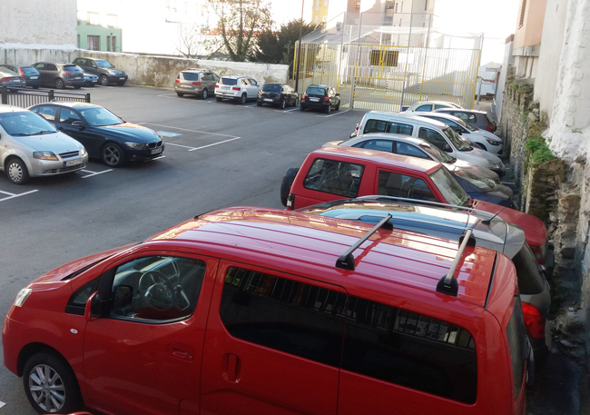 Las dos caras de los aparcamientos públicos en La Pola, uno casi vacío en las horas punta y el otro sin plazas